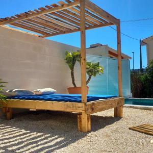 un letto in legno sotto un pergolato in legno di Casa Eline de Lujo Casco Antiguo Altea piscina privada y jardin ad Altea