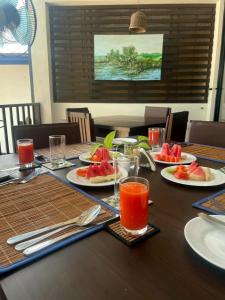 a table with plates of watermelon and glasses of juice at Wellé Wadiya Beach Villa in Kalpitiya