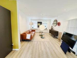 ein Wohnzimmer mit einem Sofa und einem TV in der Unterkunft Aalborg city center newly renovated house in Aalborg