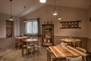 una habitación con mesas, sillas y botellas de vino en Lignanello Country House, en Pienza