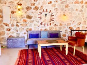 a living room with a couch and a table at Bademlique Stone Rooms in Kaş