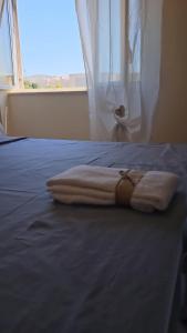 - un lit avec 2 serviettes et une fenêtre dans l'établissement Royal House Reggia, à Caserte