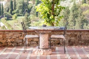 - une table en pierre et 2 chaises sur la terrasse dans l'établissement Isola del Pittore Fienile di Villa Storica, à Grassina