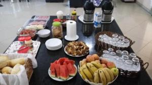 stół z talerzami żywności i owoców w obiekcie GRAN HOTEL w mieście Três Lagoas