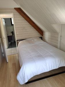 een slaapkamer met een wit bed op zolder bij Appartement Boutx in Boutx