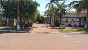 a street in front of a building with palm trees at GRAN HOTEL in Três Lagoas