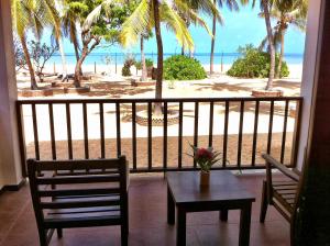 Wellé Wadiya Beach Villa في كالبيتيا: شرفة مع طاولة وكراسي وإطلالة على الشاطئ