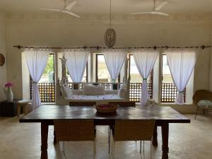 Swahili Dreams Apartments في لامو: غرفة طعام مع طاولة وأريكة