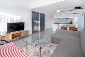 sala de estar con sofá y mesa de cristal en Vacation Flat w Pool Garden in Bodrum, en Milas