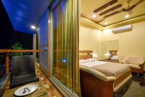 a bedroom with a bed and a balcony at hotel saptarang residency panhala in Panhāla