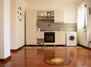 a kitchen with a washer and dryer on a wooden floor at marath houses 1 in Marta