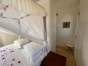 a bedroom with a white bed with a canopy at Swahili Dreams Apartments in Lamu