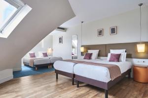 a hotel room with two beds and a staircase at Hotel Magenta 38 by Happyculture in Paris