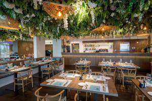 a restaurant with tables and chairs and flowers hanging from the ceiling at Giardino Lago in Locarno
