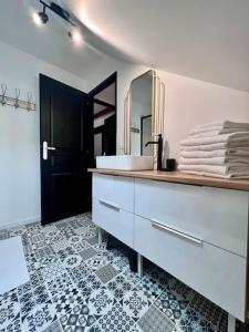 a bathroom with a sink and a mirror at Charmante & Paisible Villa Platon - Jacuzzi & Jardin - Brive in Brive-la-Gaillarde