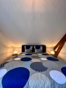 a bedroom with a blue and white bed with two lamps at Charmante & Paisible Villa Platon - Jacuzzi & Jardin - Brive in Brive-la-Gaillarde