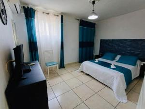 Postel nebo postele na pokoji v ubytování COQUET F2 CLIMATISE AVEC PISCINE AU LAMENTIN + 17 fotografií