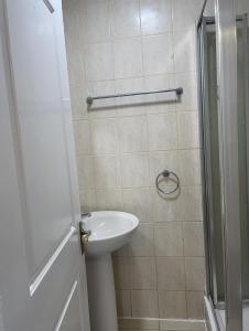 a bathroom with a sink and a shower at Immaculate 4-Bed House near Heathrow airport in Hayes