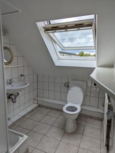 La salle de bains est pourvue de toilettes et d'un lavabo avec une lucarne. dans l'établissement Gästehaus Gröpelingen, à Brême