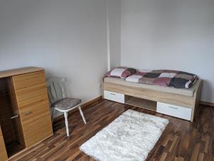 a bedroom with a bed and a dresser and a chair at Gästehaus Gröpelingen in Bremen