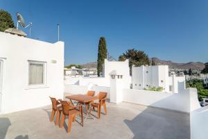a patio with a table and chairs on a white wall at Charming Flat w Terrace 3 min to Beach in Bodrum in Turgutreis