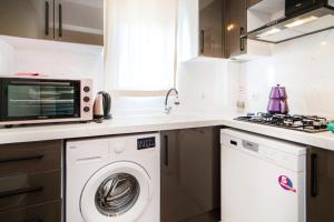 a kitchen with a washing machine and a microwave at Charming Flat w Terrace 3 min to Beach in Bodrum in Turgutreis