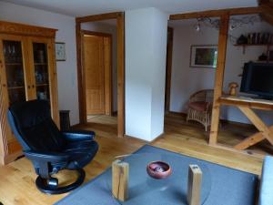 ein Wohnzimmer mit einem Stuhl und einem TV in der Unterkunft Ferienwohnungen in Schönmünzach in Baiersbronn