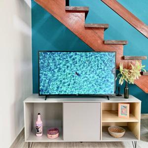 einen Fernseher, der auf einem Schrank unter einer Treppe sitzt in der Unterkunft Casa Maré Mansa: in Bertioga