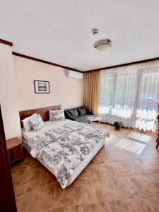 a bedroom with a bed and a couch at Private Spa Luxury apartments in Bansko