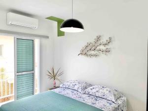 ein Schlafzimmer mit einem Bett und einem Fenster in der Unterkunft Casa Maré Mansa: in Bertioga