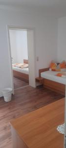 two beds in a room with wooden floors at Pension zum Park in Goldberg