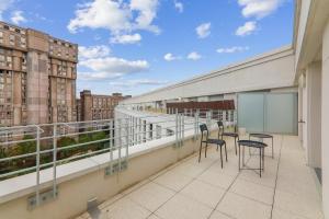 a balcony with chairs and a view of a city at Chic and spacious apart with parking in Noisy-le-Grand