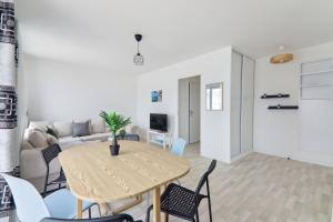 a living room with a table and chairs at Chic and spacious apart with parking in Noisy-le-Grand