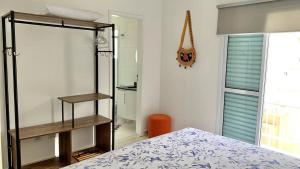 ein Schlafzimmer mit einem Bett und einem Spiegel in der Unterkunft Casa das Marés: 100M Praia da Enseada - Tranquila e Completa in Bertioga