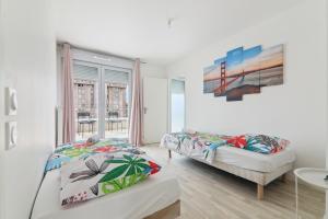 a bedroom with two beds and a window at Chic and spacious apart with parking in Noisy-le-Grand
