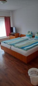 a bedroom with a large bed with a bowl on the floor at Pension zum Park in Goldberg