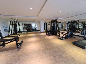 a gym with several treadmills and exercise bikes at 1 Bed Modern Apartment, Pool, Gym, Cinema in Lahore