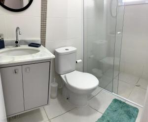 a bathroom with a toilet and a sink and a shower at Apto Moderno e Completo a 50m da Praia in Bertioga +45 photos