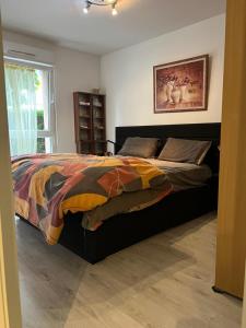 1 dormitorio con 1 cama con un edredón colorido en L’Alsace autrement, en Soultz-Haut-Rhin