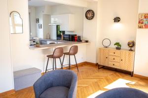uma sala de estar com duas cadeiras e uma cozinha em KASA 37 - Centre ville - Tout équipé - 2 TV em Valenciennes