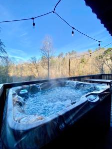 a jacuzzi tub in the backyard of a house at Fun cabin with hot tub, pool table & fire pit - BIG BLUE in Bryson City