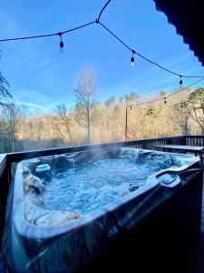 a jacuzzi tub in the backyard of a house at Peaceful cabin w/ hot tub, pool table & fire pit - BIG BLUE in Bryson City