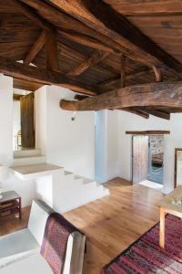 a living room with white walls and wooden ceilings at Casa de las Flores / Casa de campo LUGO in A Pontenova