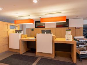 una oficina con dos escritorios y luces anaranjadas en B&B Hotel Duisburg Hbf-Nord en Duisburg