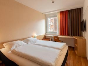 um quarto de hotel com duas camas e uma janela em B&B Hotel Duisburg Hbf-Nord em Duisburgo