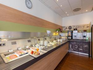 a buffet line in a restaurant with food on display at B&B Hotel Duisburg Hbf-Nord in Duisburg