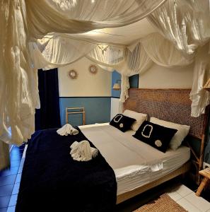 a bedroom with a bed with black and white pillows at Kaz'détente, Marie Galante, plage Kawann in Grand-Bourg