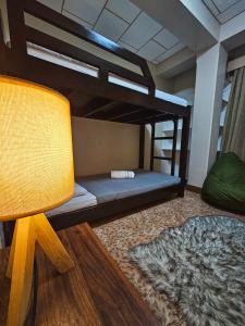 Zimmer mit Etagenbett und Lampe in der Unterkunft Mirador Modern House - Walking distance to Lourdes Grotto in Baguio City