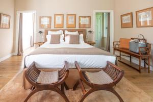 a bedroom with a large bed and two chairs at Le Clos de Grâce in Honfleur