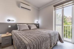 1 dormitorio con cama y ventana grande en Nocturnal Elegance Apartment by Solea, en Sliema